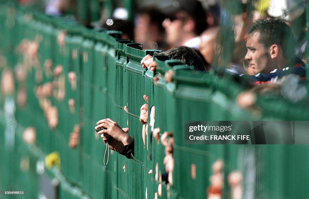 Fans behind a fence watch the French nat