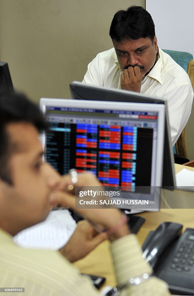 Indian stockbrokers react at a brokerage