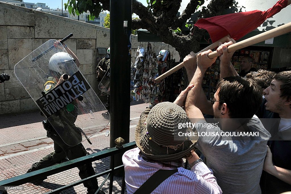 Protestors clash with riot police by the