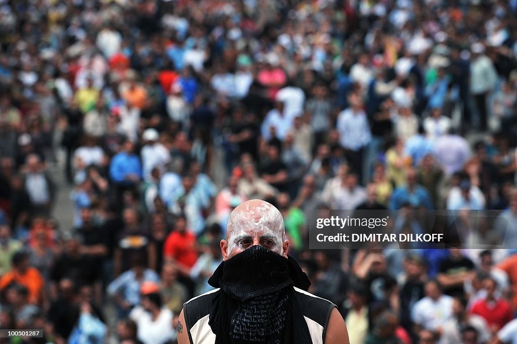 A masked protestor looks at Greek riot p