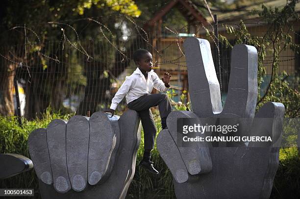 South African child plays on a sculpture on May 21, 2010 during the official celebration marking 20 days ahead of the FIFA WC2010 kick off on...