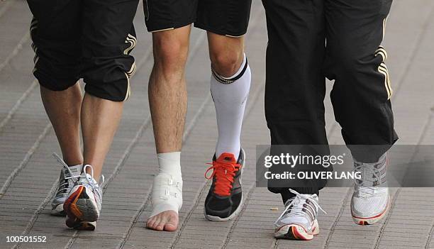 Germany's midfielder Christian Traesch is walked out of the training center by team medics after sustaining a foot injury during a training match...