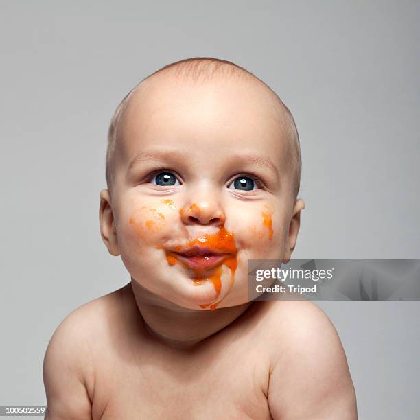 baby boy (6-9 months) with baby food on face - 6 11 maanden stockfoto's en -beelden