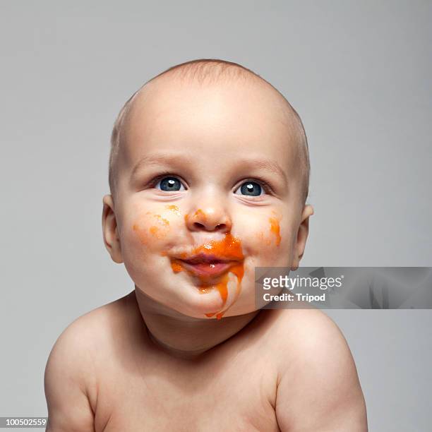 baby boy (6-9 months) with baby food on face - baby studio bildbanksfoton och bilder