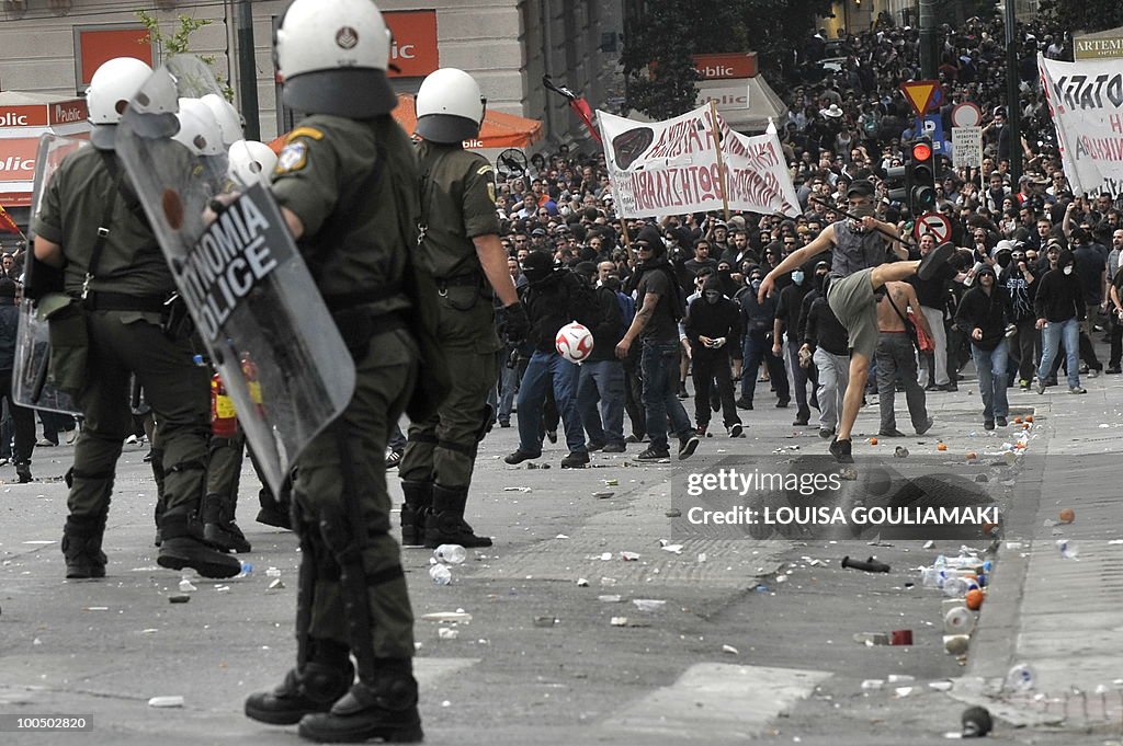 Riot police faces demonstrators during a