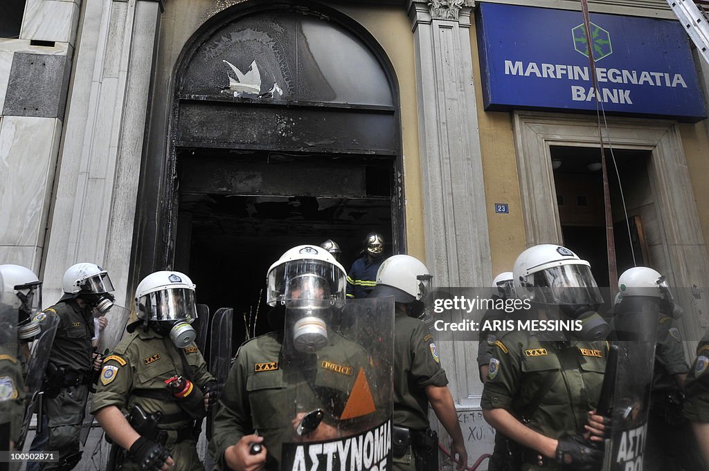 Riot police guard a burnt branch of the