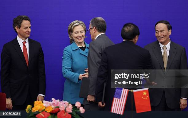 China's Vice Premier Wang Qishan and U.S. Secretary of State Hillary Clinton shake hands with bilateral delegates as U.S. Treasury Secretary Timothy...