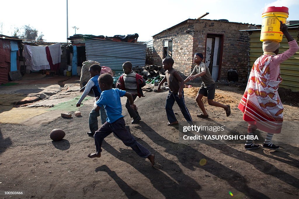 Children play football in Soweto on June