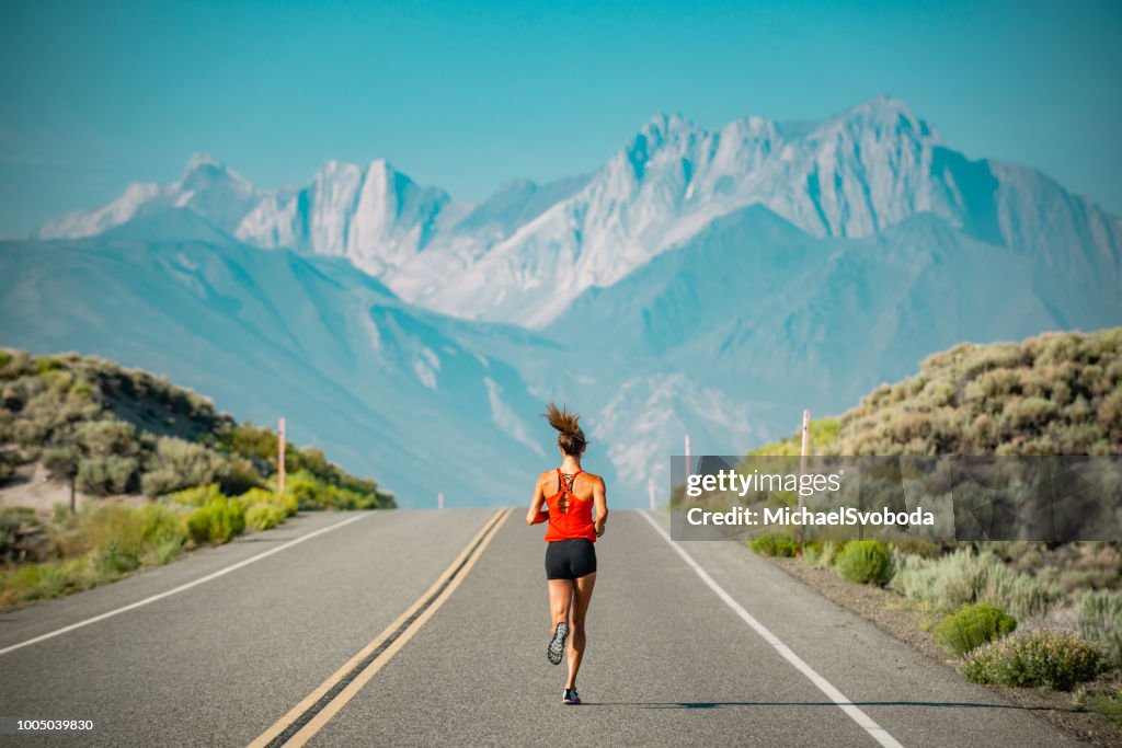 Elite Women Athlete Running Up A Road in the Sierra Mountains, California