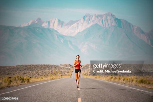 elite frauen athlet läuft eine straße in der sierra mountains, kalifornien - marathon stock-fotos und bilder