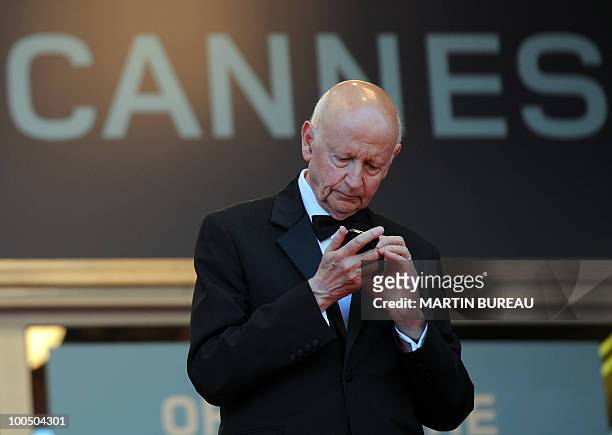 Cannes Film Festival President Gilles Jacob looks at his phone as guests arrive for the screening of "Utomlyonnye Solntsem 2: Predstoyanie" presented...