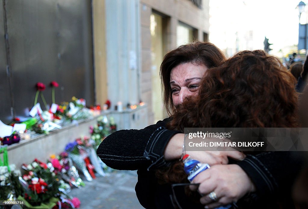 Women cry on May 7, 2010 in front of a b