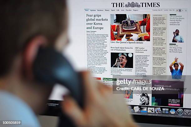 Man is seen looking at The Times newspaper's new website on a computer, in this posed picture, taken in central London on May 25, 2010. News...