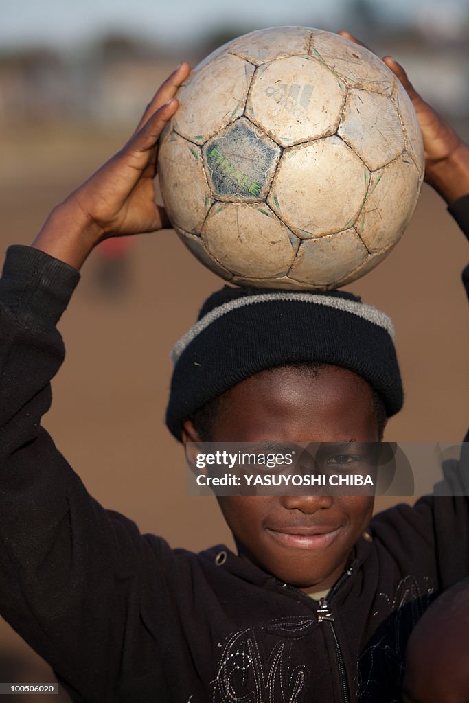 A child holds a football in Soweto on Ju