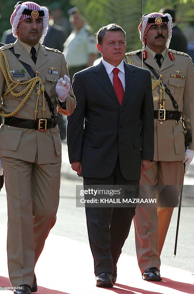 Jordan's King Abdullah II (C) reviews a