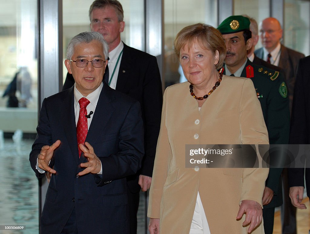 German Chancellor Angela Merkel walks wi