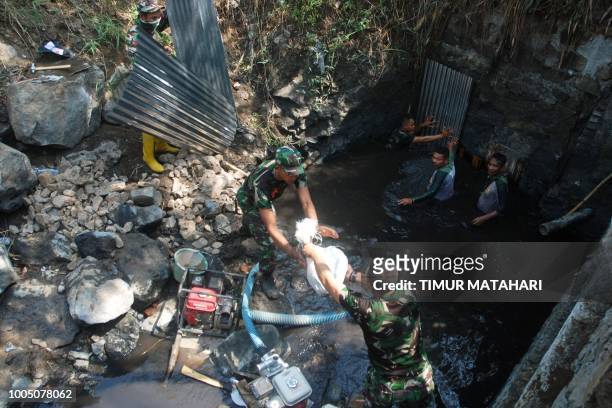This picture taken on July 24 shows Indonesian soldiers and members of the Citarum River Task Force blocking a sewage channel after the Mitra Citarum...