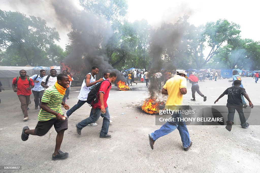Haitian students run around burning tire