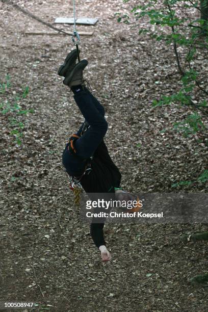 Climber Can Akguen hangs on a rope at the GHW tightrobe climbing garden on May 25, 2010 in Hueckeswagen, Germany.