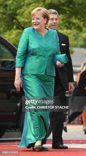 German Chancellor Angela Merkel and her husband Joachim Sauer arrive for the opening of the annual Bayreuth Festival featuring the music of Richard...