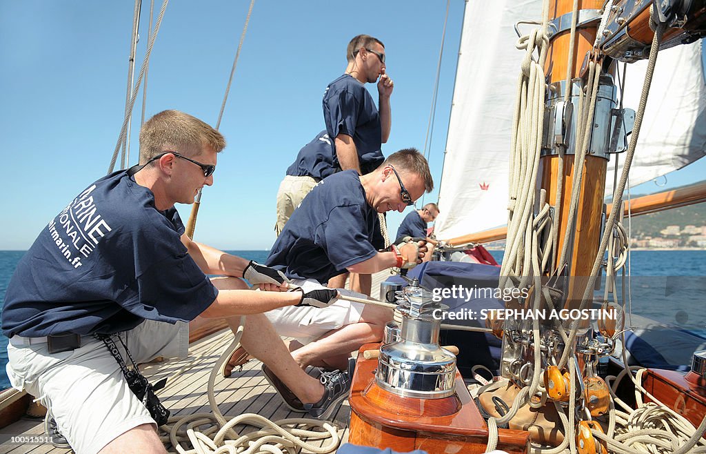 Crew members of a luxury yacht manoeuvre