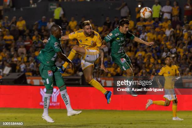 Andre-Pierre Gignac of Tigres heads the ball with Andres Mosquera and Fernando Navarro of Leon to scores his team's second goal during the 1st round...