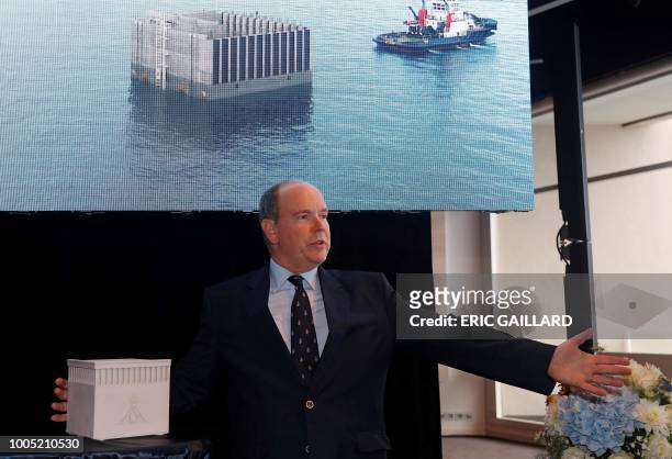Prince Albert of Monaco poses with a model the principality's offshore land reclaimation extension project - concrete-filled chambers called...