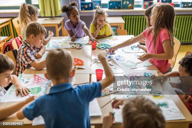 large group of elementary students having an art class in the classroom. - arts and crafts supplies stock pictures, royalty-free photos & images