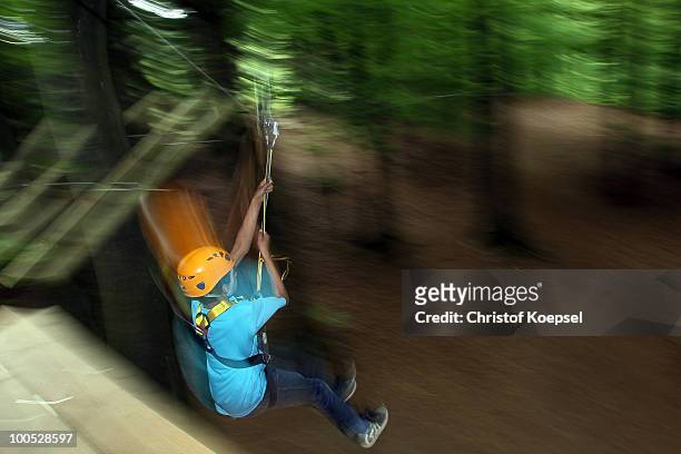Climber Benny hangs on a rope at the GHW tightrobe climbing garden on May 25, 2010 in Hueckeswagen, Germany.
