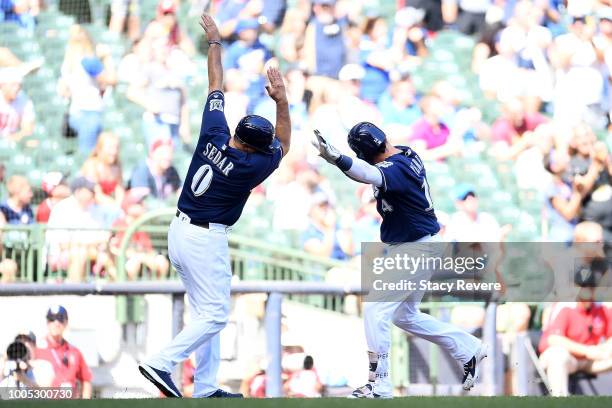 Hernan Perez of the Milwaukee Brewers celebrates a home run with third base coach Ed Sedar during the ninth inning of a game against the Washington...