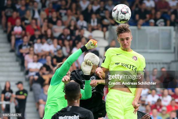 Soeren Reddemann of SV Wehen Wiesbaden challenges Felix Wiedwald of Eintracht Frankfurt during the Pre Season Friendly Match between SV Wehen...