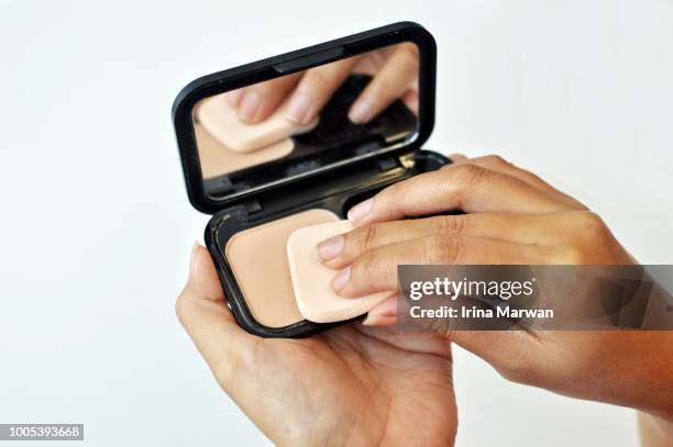 make-up: woman using compact face powder - compact foto e immagini stock