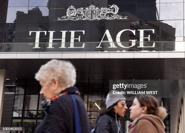 People walk past the offices of Fairfax Media's The Age newspaper in Melbourne on July 26, 2018. - Publisher Fairfax Media and Nine Entertainment...