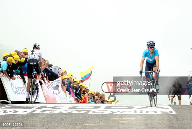 Alejandro Valverde of Spain and Movistar Team finishing while Chris Froome of Great Britain and Team Sky goes to his team's bus down the hill...