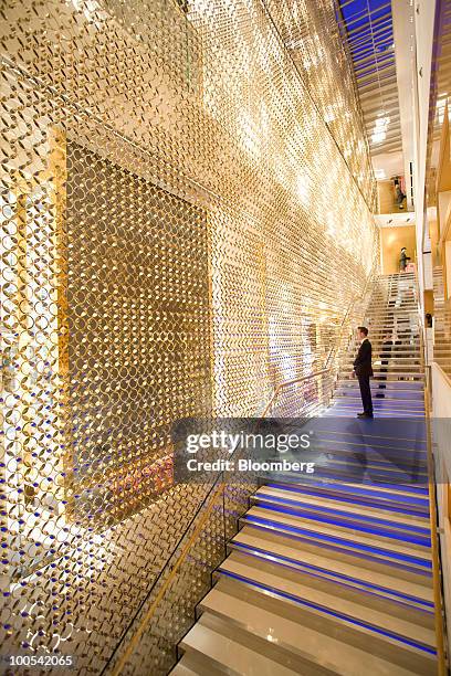 Customer inspects the interior of the Louis Vuitton "maison," the London flagship store for LVMH Moet Hennessy Louis Vuitton SA, in New Bond Street...