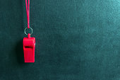 Sports whistle on a red lace.Concept- sport competition, referee, statistics, challenge, friendly match.