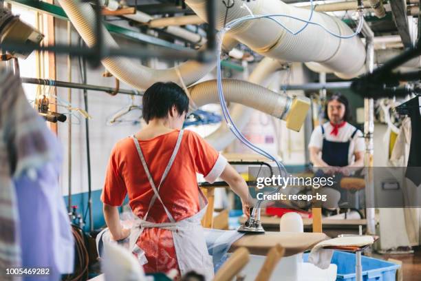 twee mensen die werken in stomerij shop - stomerij stockfoto's en -beelden