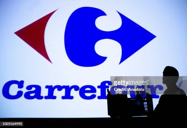 Silhouette of a man staring at the logo of Carrefour in Ankara, Turkey on July 26, 2018.