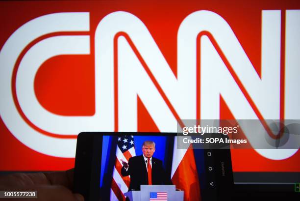 In this photo illustration, a mobile phone shows President of United States of America, Donald Trump with CNN logo in the background.