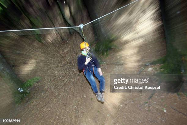Climber Can Akguen hangs on a rope during a climbing session at the GHW tightrobe climbing garden on May 25, 2010 in Hueckeswagen, Germany.