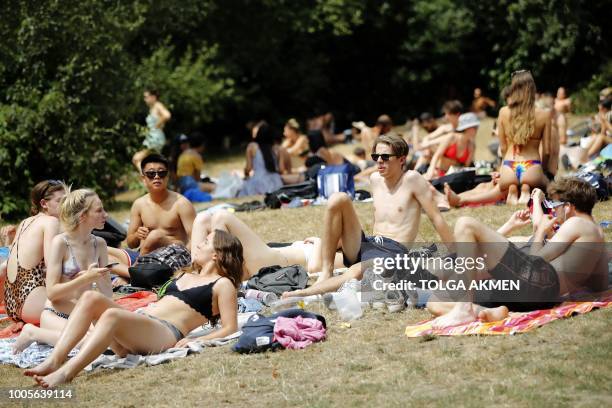 Sunbathers relax on Hampstead Heath in London on July 26, 2018. - Britain has been in the grip of its longest heatwave in decades, sparking wildfires...