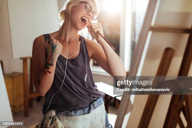 girl painting and listening to music - passion work stock pictures, royalty-free photos & images