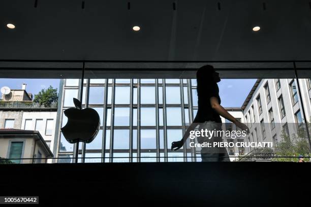 Woman walks past the Apple logo at the new Apple Store Liberty, the first Italian flagship store of Apple in Milan, on July 26, 2018.