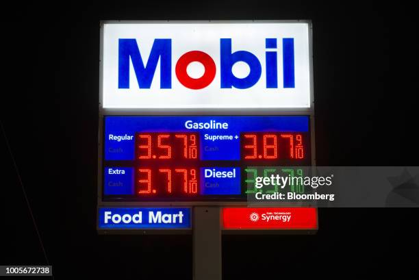 Signage displays fuel prices at an Exxon Mobil Corp. Gas station at night in Seattle, Washington, U.S., on Tuesday, July 24, 2018. Exxon Mobil Corp....