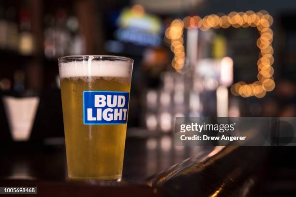 In this photo illustration, a glass of Bud Light sits on a bar, July 26, 2018 in New York City. Anheuser-Busch InBev, the brewer behind Budweiser and...