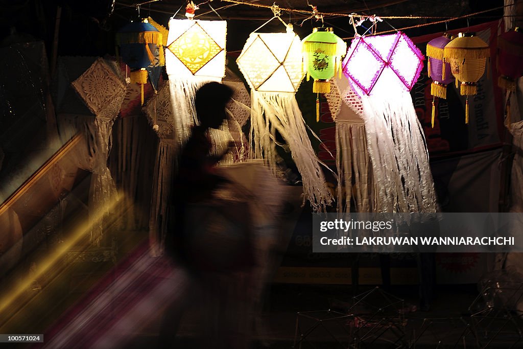 A Sri Lankan shop owner hangs lanterns f