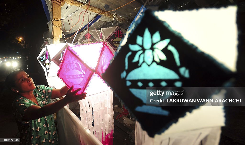 A Sri Lankan shop owner hangs lanterns f