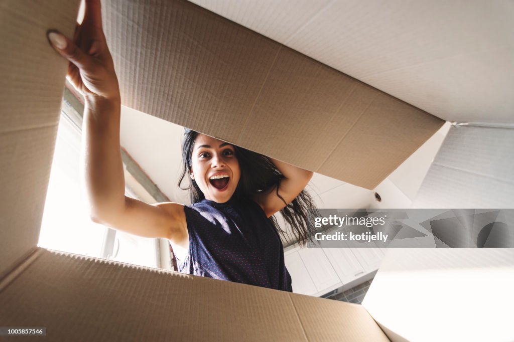 Smiling woman opening a carton box