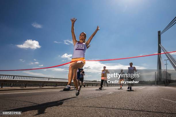 unter ansicht des erfolgreichen marathon-läufer über die ziellinie. - marathon ziel stock-fotos und bilder