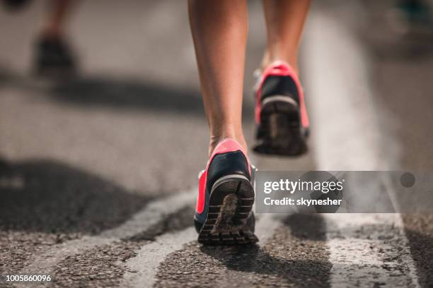 close up of unrecognizable marathon runner in motion on the road. - woman marathon stock pictures, royalty-free photos & images